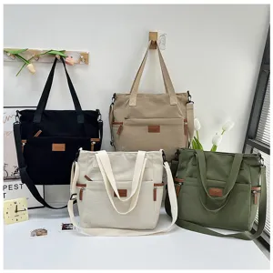 Detail view of multi-color corduroy tote bags with cross body straps and front pockets.