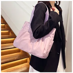 Close-up detail of a light purple nylon tote bag worn by a model, casual and stylish.