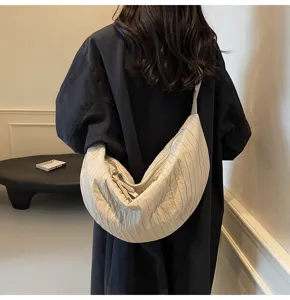 Dettaglio della borsa a tracolla plissettata minimalista beige, grande capacità casual.