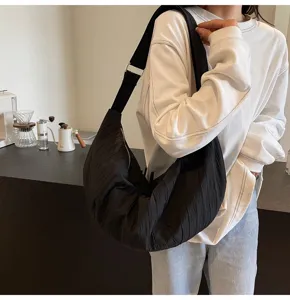 Vista di dettaglio della borsa a tracolla nera plissettata, con tessuto morbido e design casual.