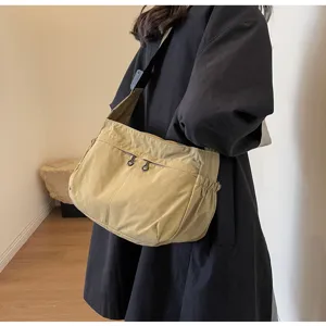Vista dettagliata della borsa a tracolla in nylon kaki con zip e tasche laterali.