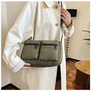Green nylon crossbody shoulder bag detail, multi-pocket canvas daily commuter handbag.