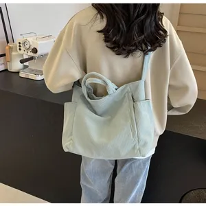 Detailed view of light blue corduroy tote bag, side pocket design, casual everyday commuter style.