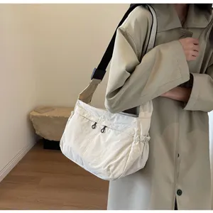 Vista dettagliata della borsa a tracolla in nylon casual indossata per uso quotidiano.