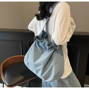 Detailed view of casual blue nylon shoulder bag, lightweight commuter tote bag for women daily use.