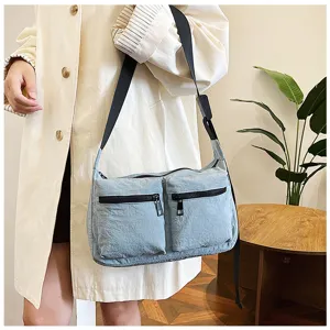 Casual fashion women crossbody bag detail shot showing blue nylon fabric with dual pockets.