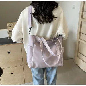 Detail view of the light purple nylon tote bag worn on shoulder, showing casual style.