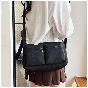Casual black nylon crossbody bag for women with dual front pockets and adjustable strap.