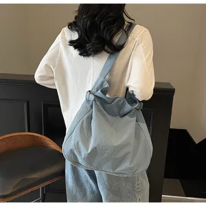 Detail view of casual blue nylon shoulder bag, slouchy tote design for daily commute.