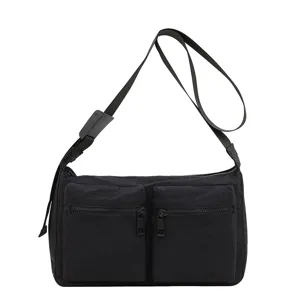 Black nylon crossbody shoulder bag with dual front zip pockets for daily commute.