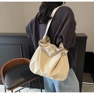 Detailed lifestyle view of the minimalist nylon shoulder bag showing its casual slouchy fit.