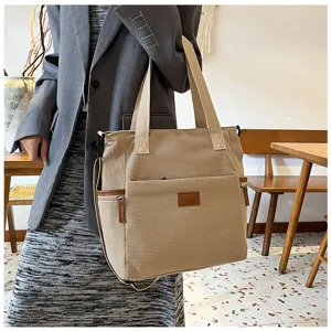 Detail view of the elegant corduroy tote bag highlighting the front pocket and sturdy handle.