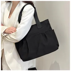 Detail view of black nylon tote shoulder bag with spacious compartment and convenient side pockets.