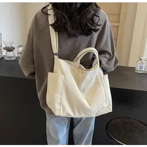 Detail view of a large white corduroy tote bag, versatile shoulder and crossbody style.