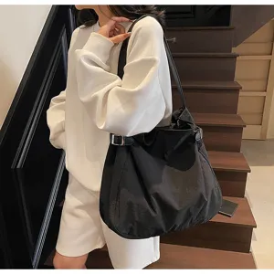 Detail view of the casual black nylon shoulder bag, showing durable fabric and metal buckle.