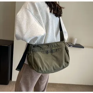 Vista dettagliata della borsa a tracolla in nylon casual con tessuto scuro, zip e cinghia.
