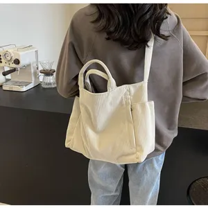 Casual beige corduroy tote bag lifestyle detail shot showing shoulder strap and fabric texture.