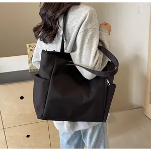 Detailed view of large capacity black nylon tote bag, casual daily shoulder handbag.