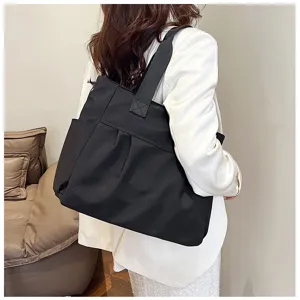 Detailed view of the large capacity black nylon tote bag showing side pockets for daily use.
