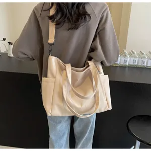 Detail view of casual nylon tote bag worn on shoulder, large capacity daily crossbody design.
