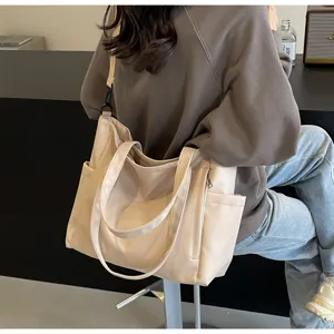 Detailed view of casual beige nylon tote bag with side pockets and shoulder strap.