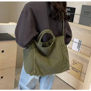 Detail view of large capacity corduroy tote bag with shoulder strap and side pockets.