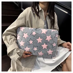 Close-up detail of cozy gray plush laptop sleeve with cute pink star patterns for daily use.