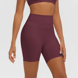 Primo piano dettagliato di pantaloncini da yoga bordeaux a vita alta in tessuto elasticizzato.