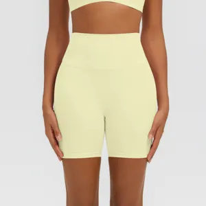 Dettaglio di pantaloncini da yoga sportivi a vita alta in giallo chiaro, tessuto morbido.