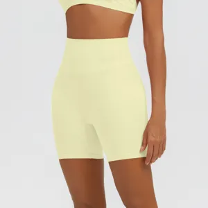 Dettaglio di pantaloncini da yoga fitness traspiranti da donna a vita alta in giallo.
