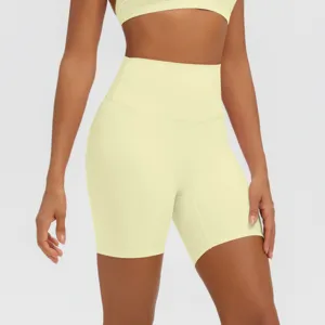 Primo piano di pantaloncini da yoga a vita alta da donna in giallo chiaro, tessuto sportivo.
