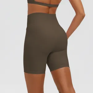 Dettaglio di pantaloncini da yoga marroni a vita alta con cuciture modellanti e supporto.