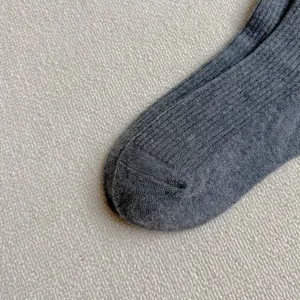 Primo piano di calzini in maglia a coste grigie, morbido misto cotone per l'inverno quotidiano.