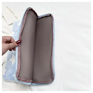 Detailed view of soft blue plush star tablet sleeve interior, cozy lining, secure zipper.