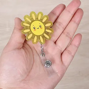 Close-up detail of cute glitter sunflower retractable badge reel clip for ID work cards.