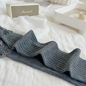 Chaussettes hautes côtelées gris foncé avec bordure en dentelle délicate, bas longs confortables.