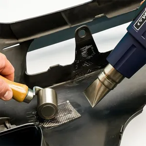 Stainless steel repair mesh detail shot showing hot air gun welding process for car bumper.
