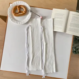 Gambe lavorate a maglia bianche con nastri decorativi, calzini in stile giapponese graziosi.
