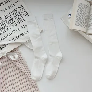 Chaussettes hautes blanches pour femmes, chaussettes longues unies pour la mode quotidienne.