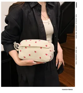 Corduroy strawberry makeup bag display showing soft textured fabric and portable handle.