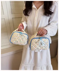 Quilted floral cosmetic bag with blue trim and zipper, portable makeup storage for daily use.