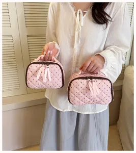 Detailed view of the pink quilted polka dot makeup bag, featuring cute bow ribbon zipper pulls.
