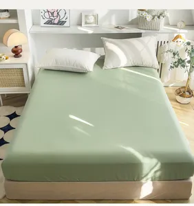Katoenen hoeslaken detailweergave, zachte saliegroene stof en gezellige slaapkamer sfeeropstelling.