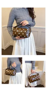 Detailed view of brown PU leather cosmetic bag with white polka dots, stylish handheld design.
