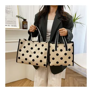 Close-up detail of the stylish polka dot canvas tote bag, featuring sturdy handles and pattern.