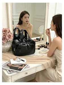 Black leather cosmetic bag detail, multi-functional travel toiletry organizer with zippers.