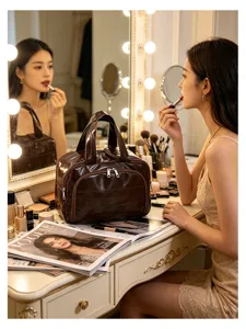 Detailed view of the dark brown leather cosmetic bag on a stylish vanity table setup.