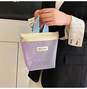 Detailaufnahme einer lila Netzkosmetiktasche mit hübschen Pastellgriffen und Reißverschluss.