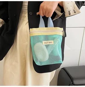 Detailaufnahme einer farbenfrohen Netzkosmetiktasche mit doppelten Griffen und Reißverschluss.