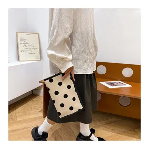 Close-up view of the chic polka dot cosmetic pouch, displaying the stylish fabric texture.